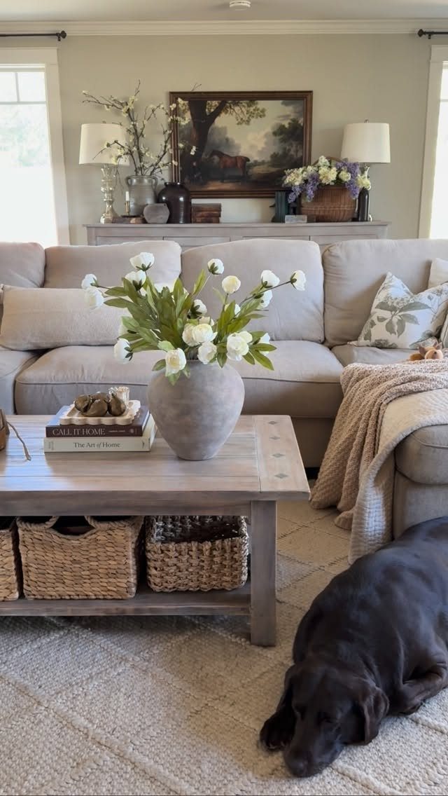 A beige sectional sofa and wooden coffee table in a cozy, farmhouse-style living room.