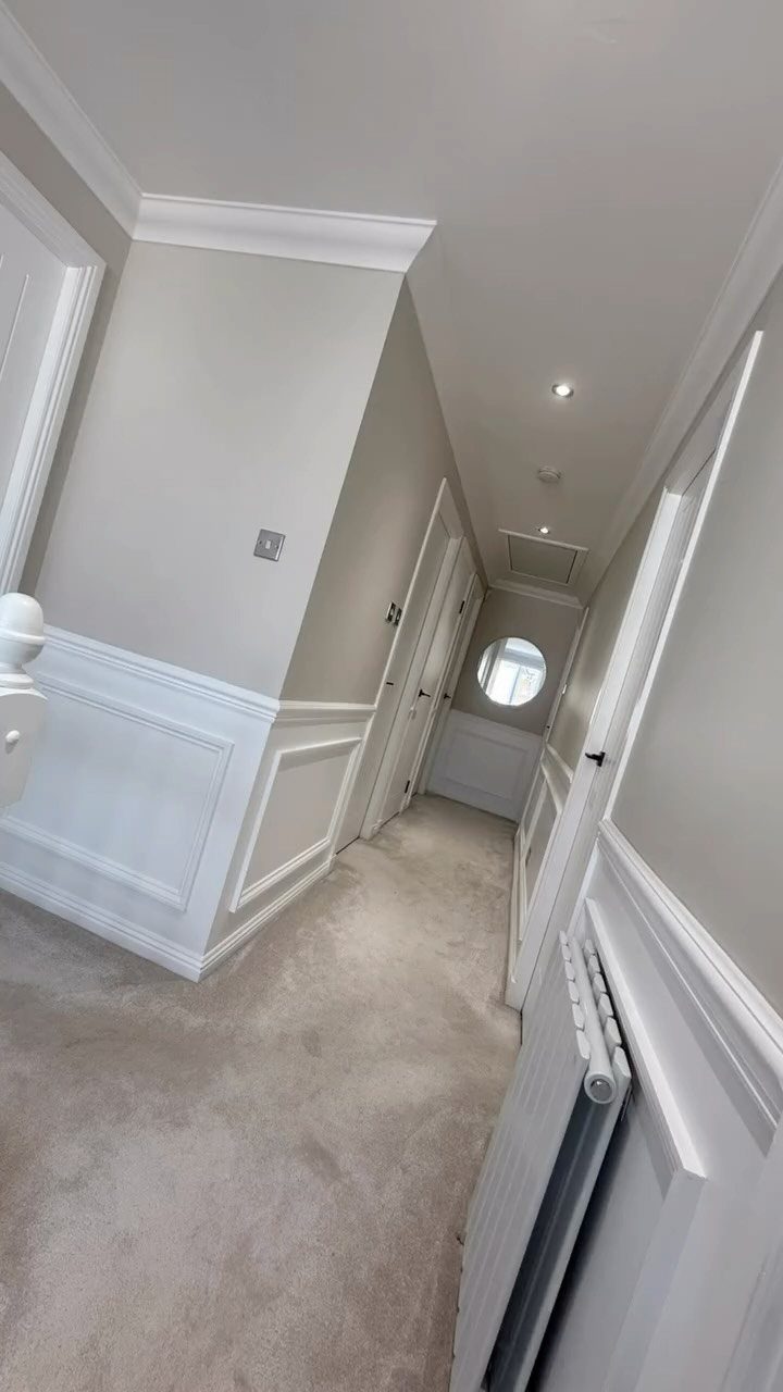 White wainscoting paneling installed on the lower half of walls in a narrow hallway.