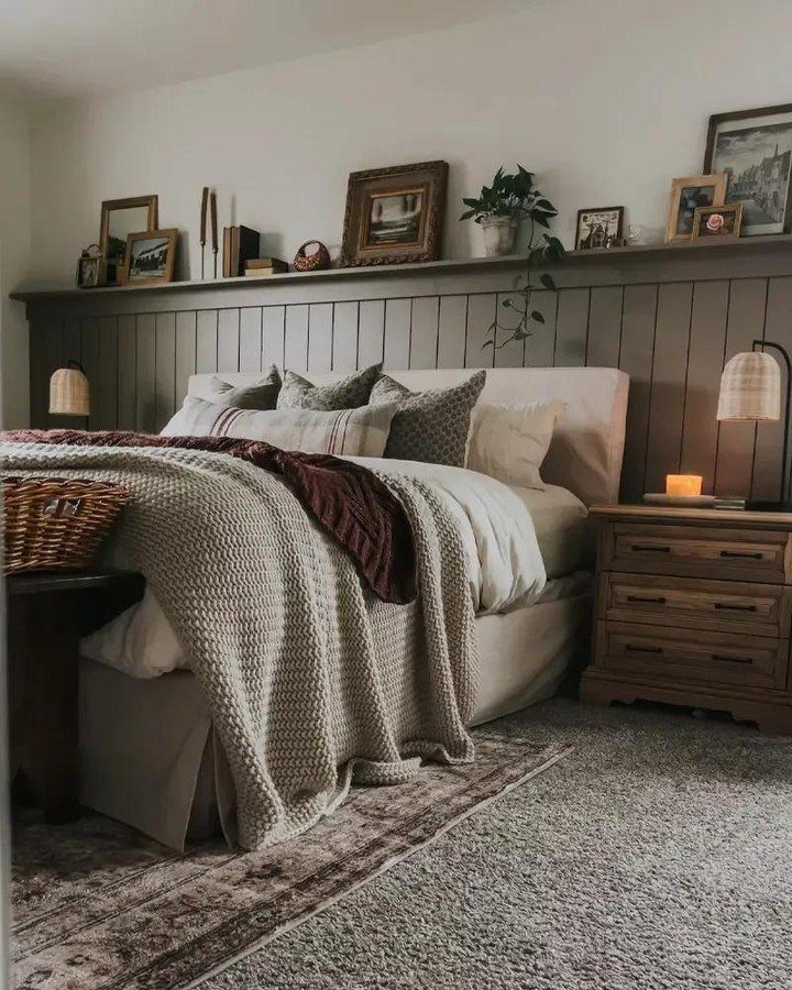 Dark grey wainscoting paneling behind a bed with neutral bedding and wooden nightstands.