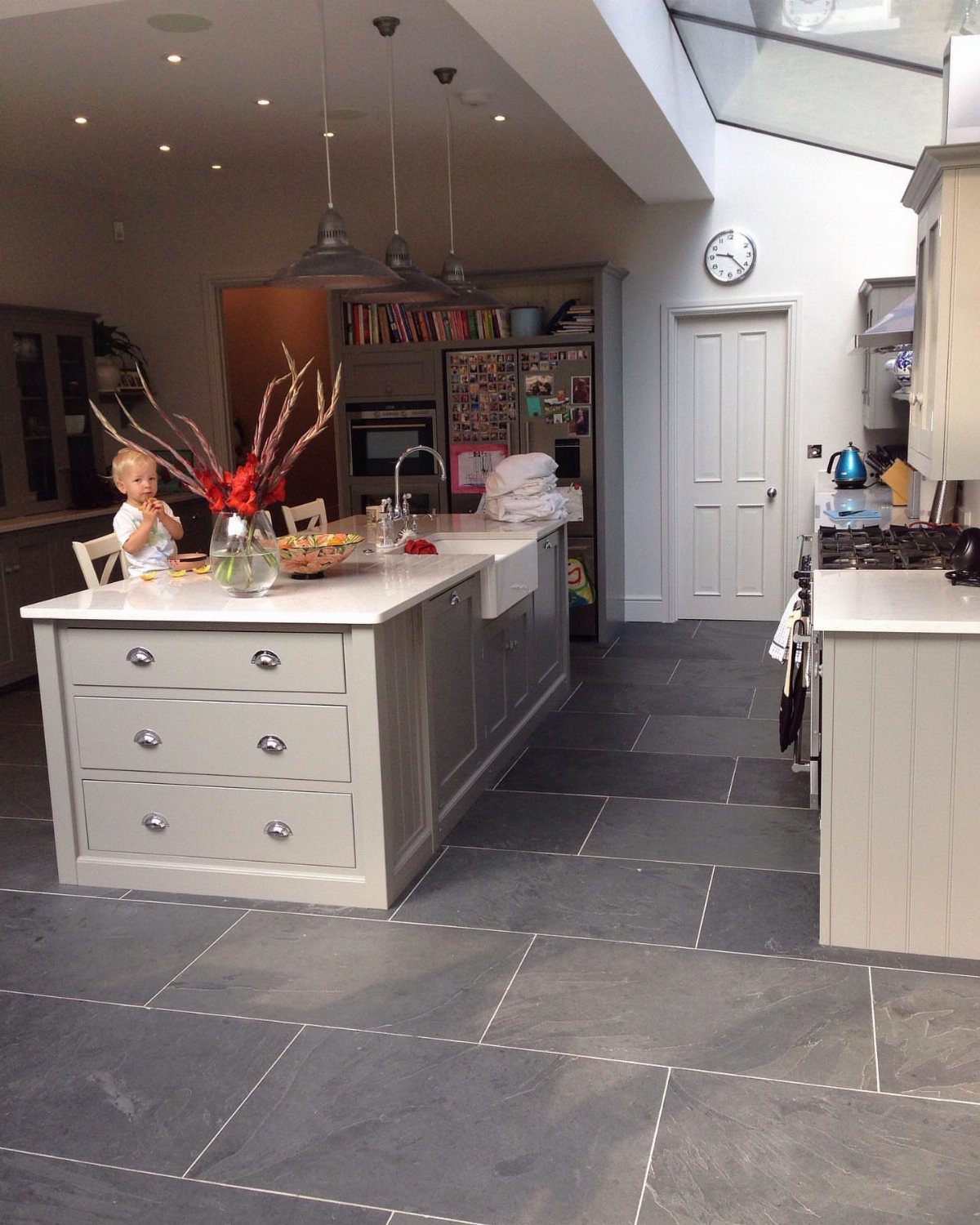 Kitchen Flooring for White Cabinets: 11 Ideas That Actually Work 1 Dark gray stone tiles cover the floor of a modern kitchen with light gray cabinetry.
