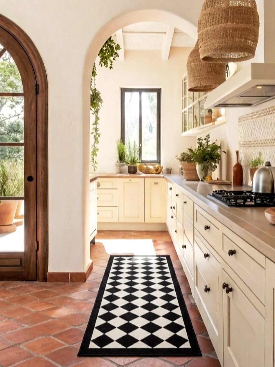 Kitchen Flooring for White Cabinets: 11 Ideas That Actually Work 8 Cream kitchen cabinets and terracotta tile flooring with a black and white checkered rug.