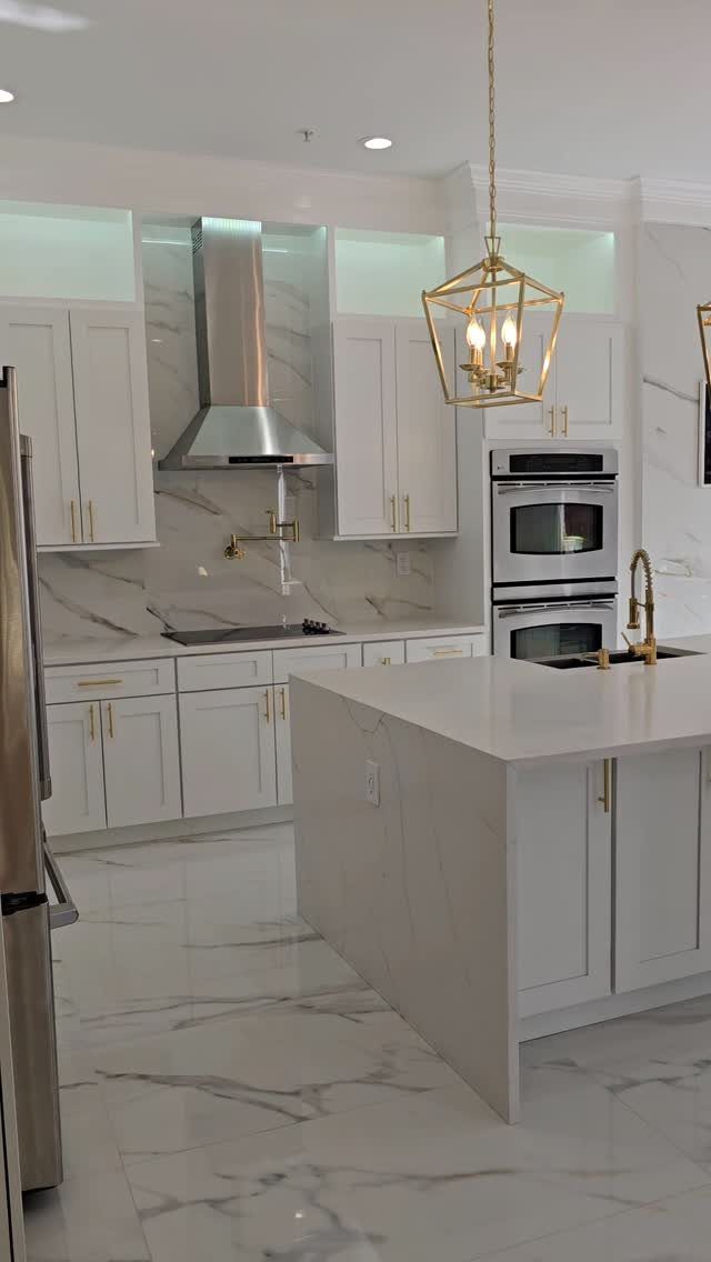Kitchen Flooring for White Cabinets: 11 Ideas That Actually Work 6 Modern kitchen with white cabinets, marble island, and white marble-patterned flooring.