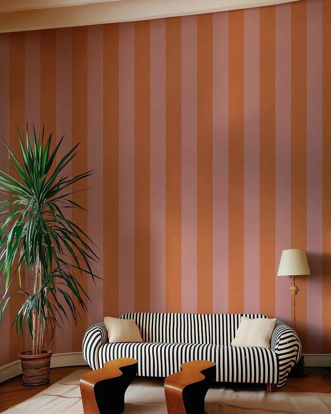 Terracotta and pink vertical striped accent wall behind a black and white striped sofa.