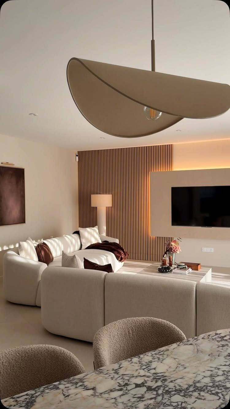 Modern living room with a beige sofa and a vertical wood slat accent wall.