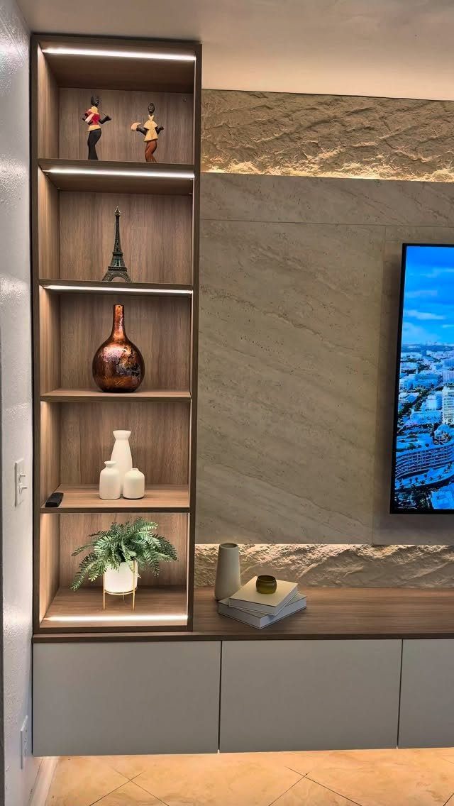 Vertical wood shelving unit with integrated LED lighting displaying various decorative home decor items.