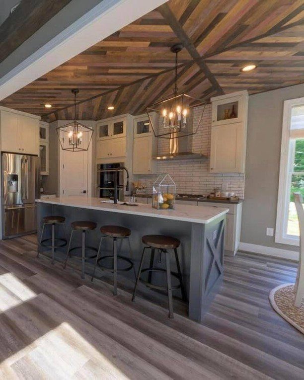 Grey wood-look vinyl flooring in a bright, modern farmhouse kitchen with a large island.
