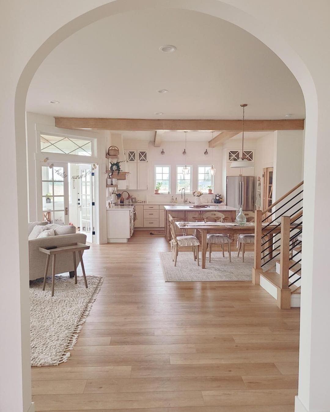 Light wood wide plank flooring in a bright, open-concept modern farmhouse living and kitchen area.
