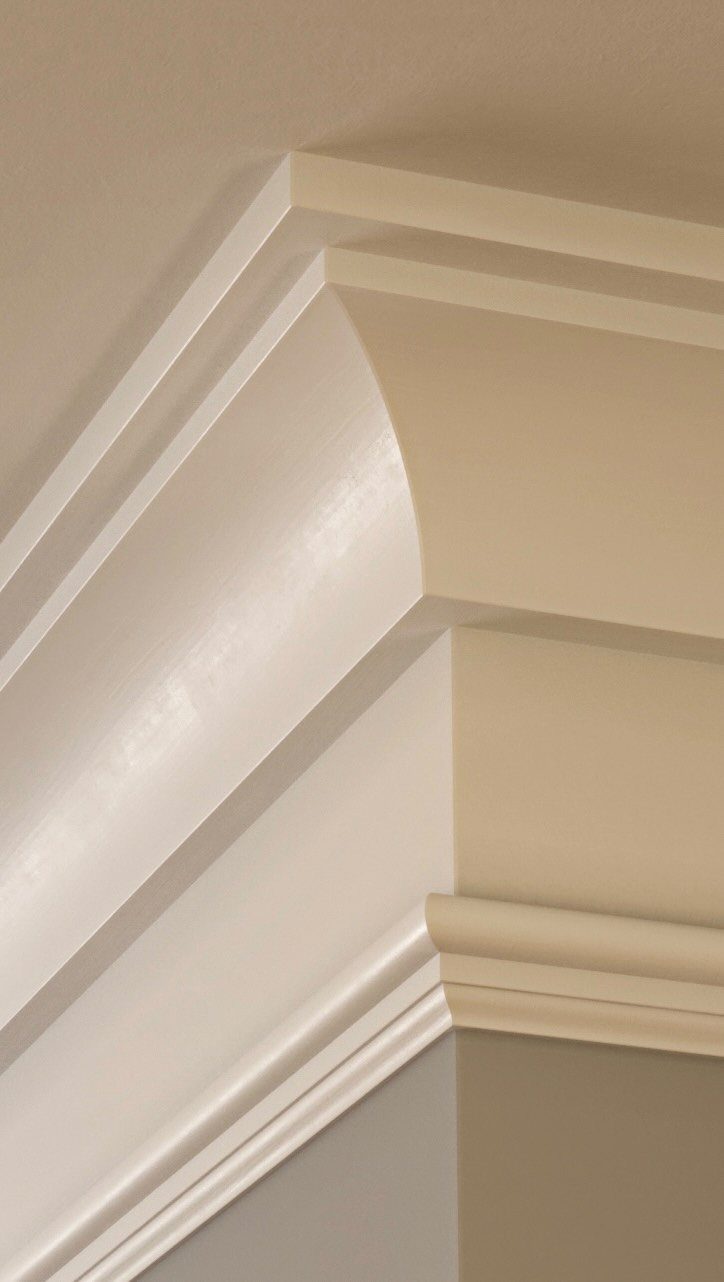 Wall Moulding Design: 11 Styles That Work in Every Room 7 White decorative crown moulding installed at the corner of a beige wall and ceiling.