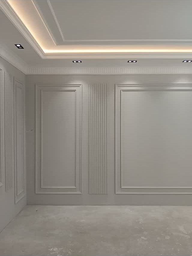 Wall Moulding Design: 11 Styles That Work in Every Room 10 White walls with decorative rectangular moulding and vertical fluted panels in an empty room.