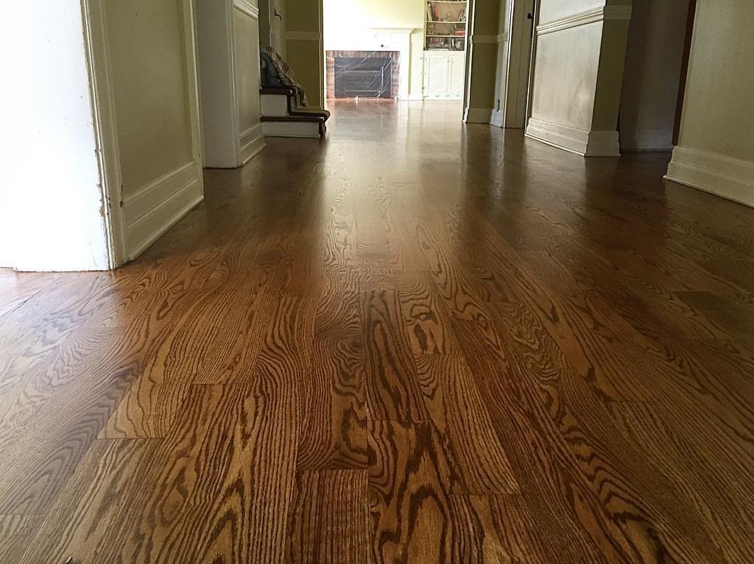 Polished oak hardwood flooring with a warm medium brown stain and visible wood grain.