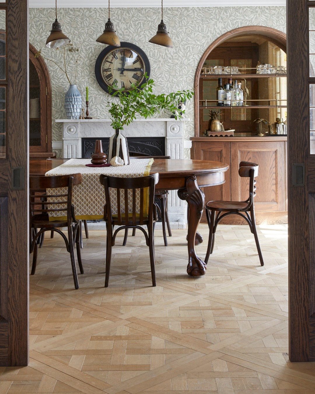 Light wood parquet flooring with a geometric pattern in a dining room setting.