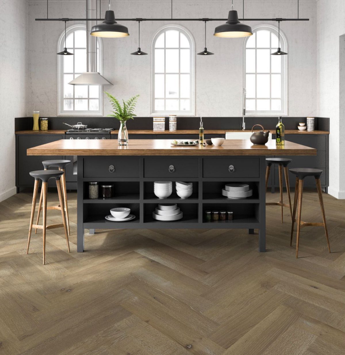 Herringbone pattern hardwood flooring in a modern kitchen with a large dark grey island.