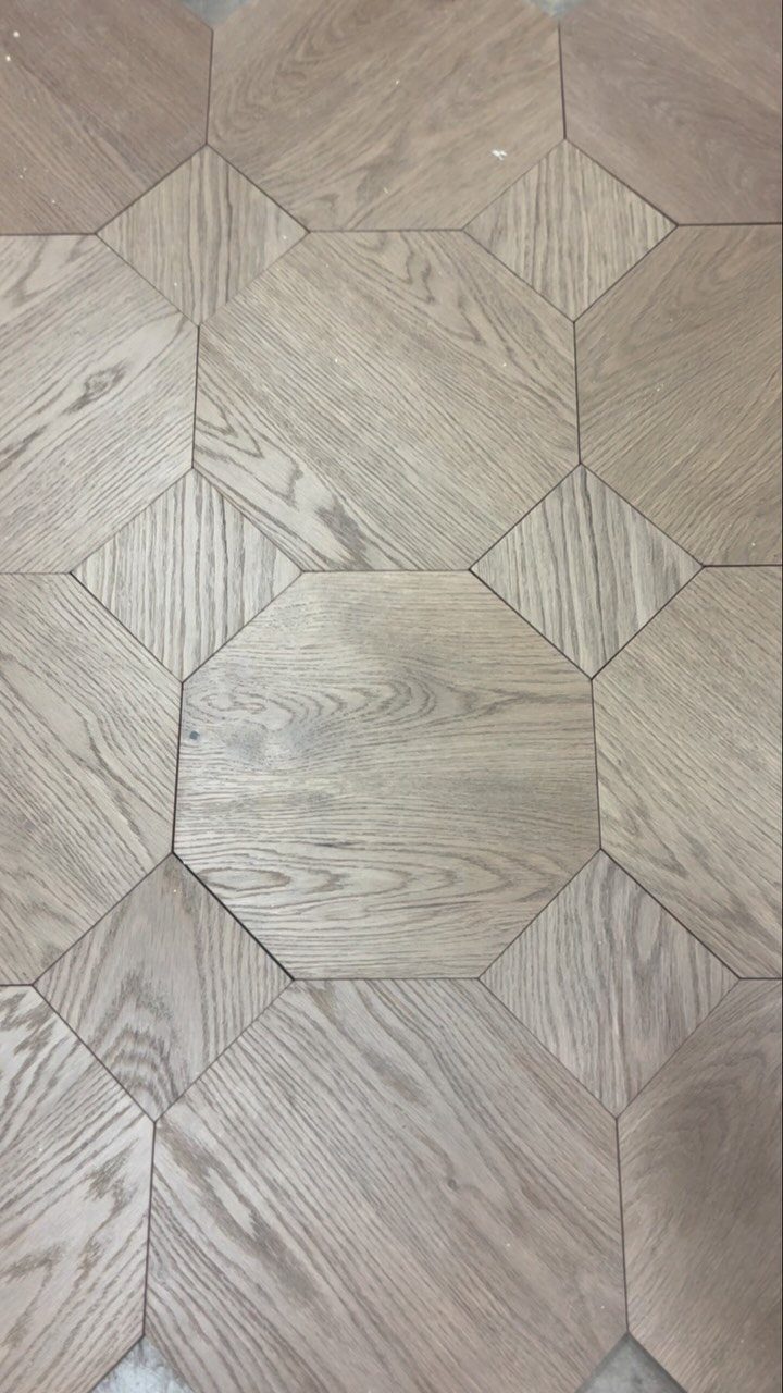 Light brown wood flooring with a geometric pattern of large octagons and small diamond shapes.
