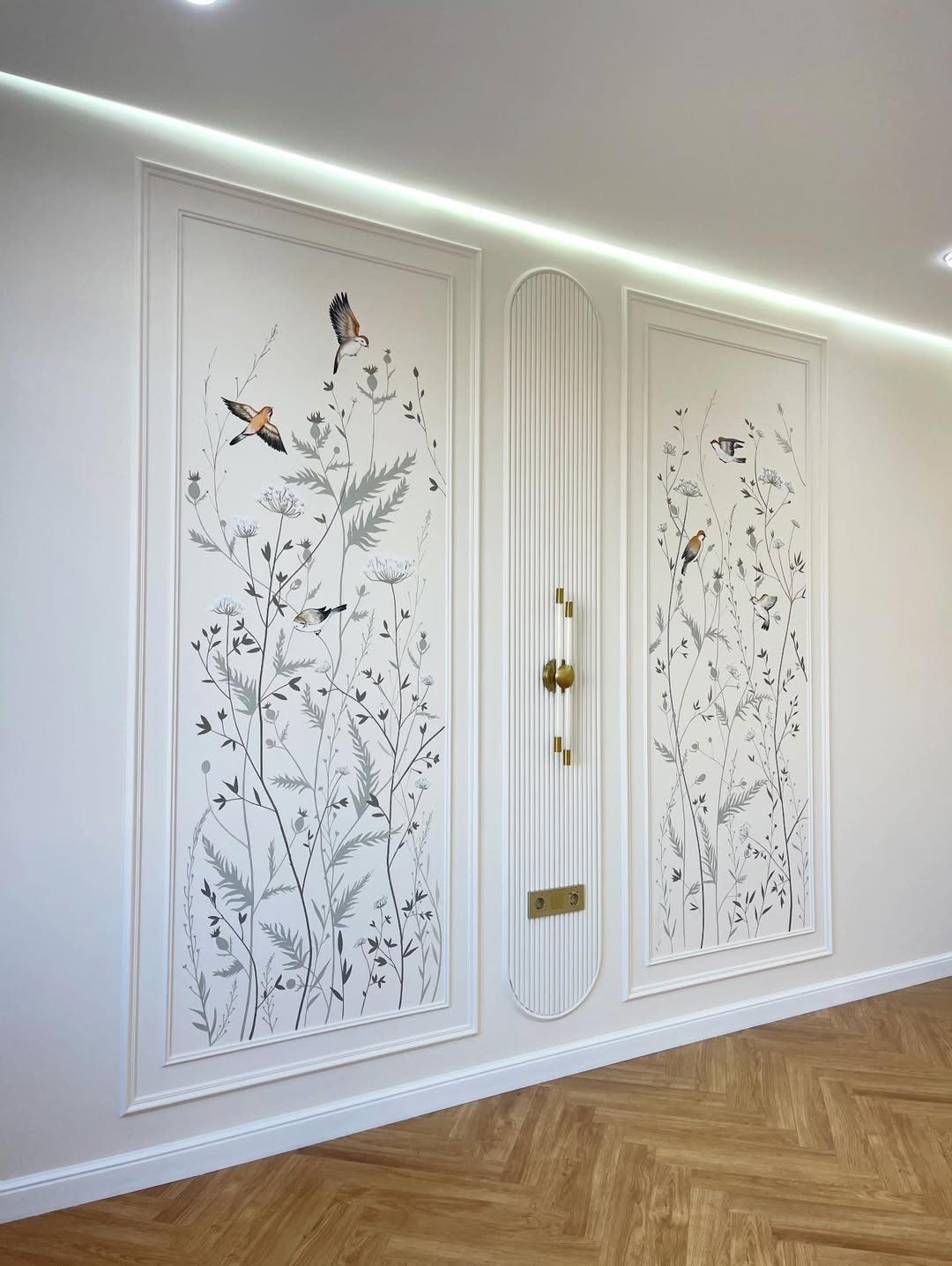 White wall with large decorative picture frame molding and botanical bird wallpaper.