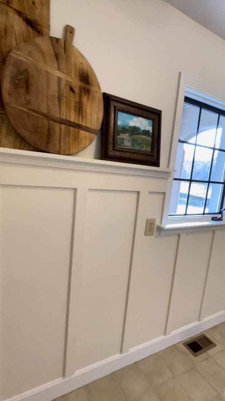 Types of Wall Paneling: 10 Styles for Any Room 2 White board and batten wainscoting on a wall with a shelf and window.