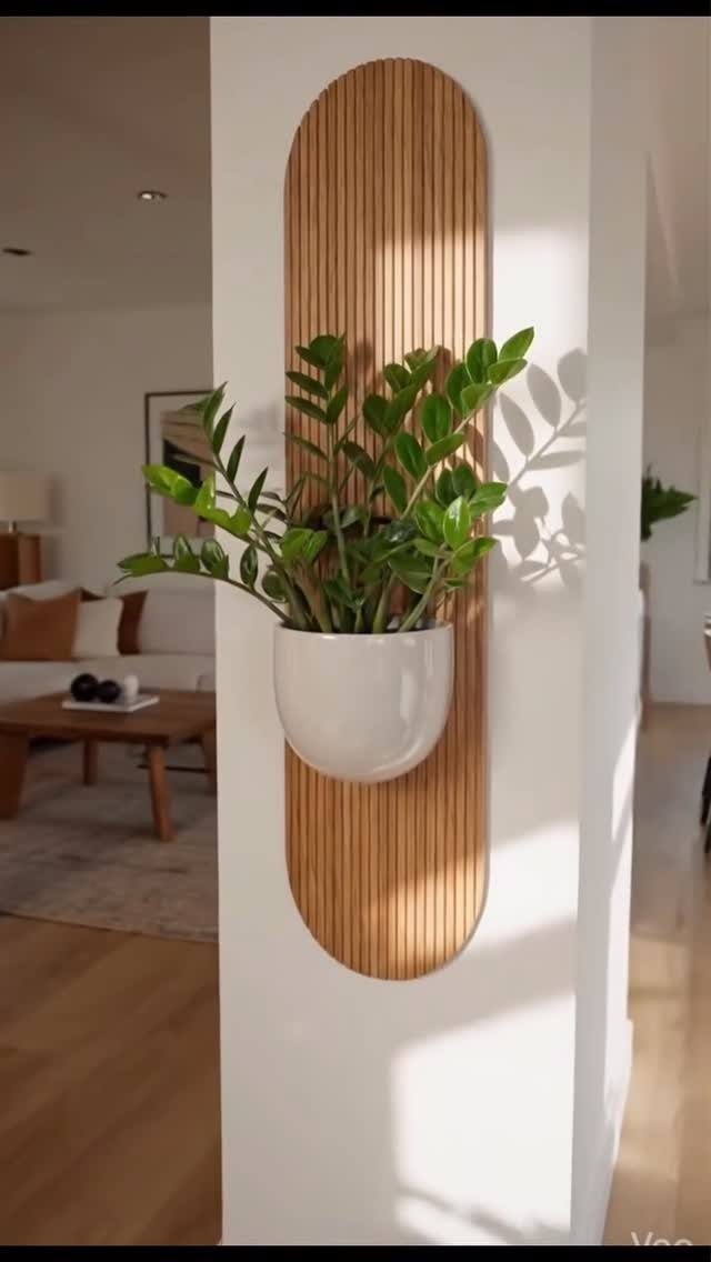 A green plant in a white pot mounted on a vertical wooden slat wall panel.