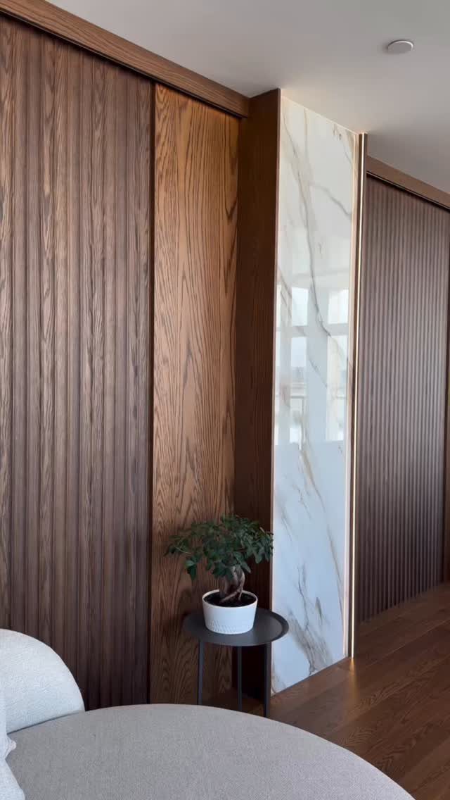 Wood Panelling on Walls: 8 Styles That Read as Architecture 1 Dark and light brown wood panelling on walls with a marble accent piece.