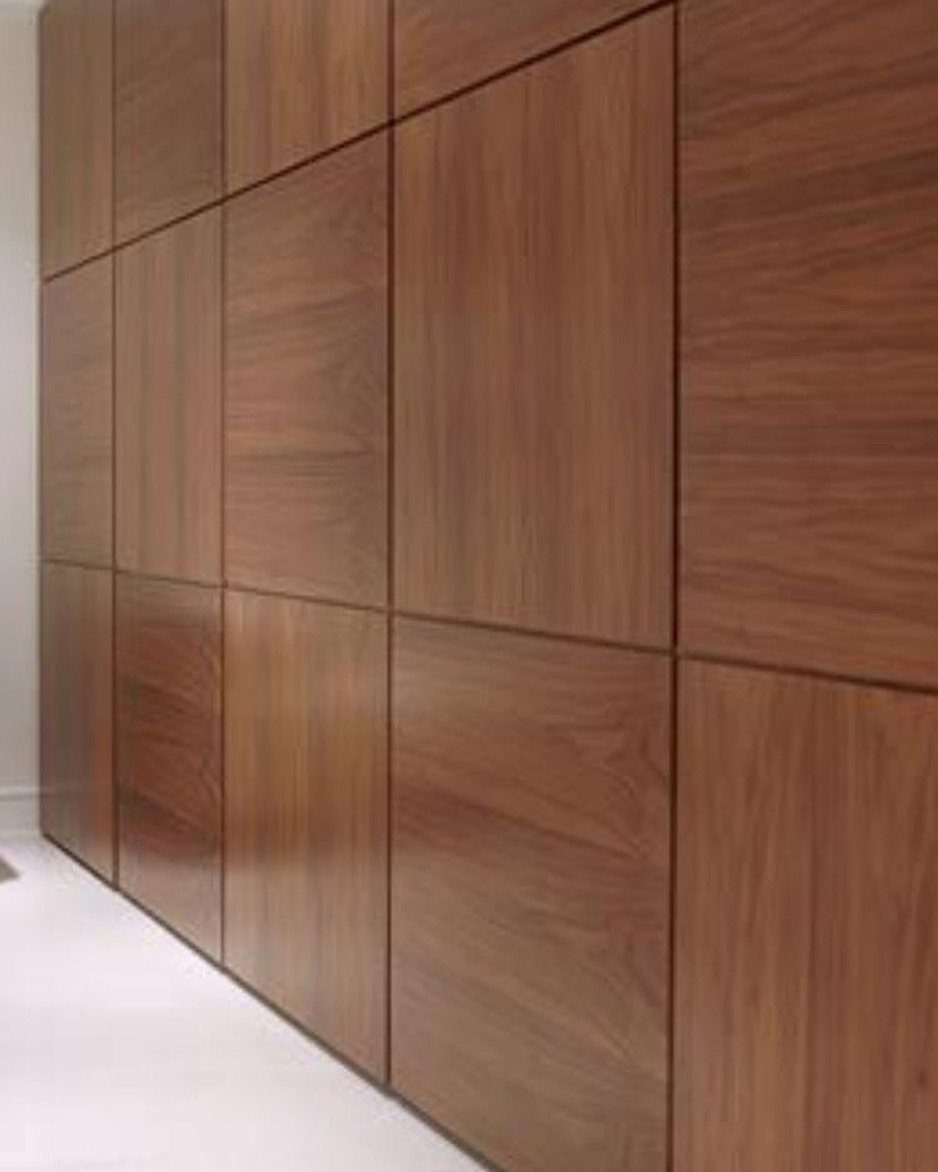 Wood Panelling on Walls: 8 Styles That Read as Architecture 6 Large rectangular dark brown wood panels arranged in a grid pattern on a wall.