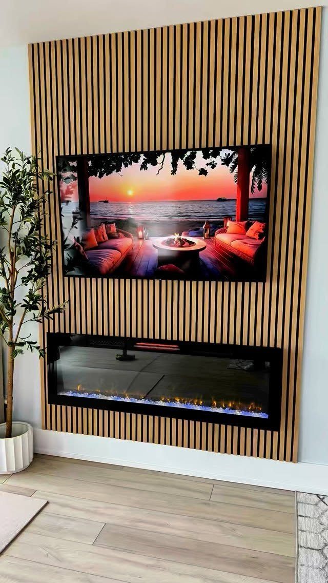 Wood Panelling on Walls: 8 Styles That Read as Architecture 4 Vertical light wood slats covering a wall behind a television and a modern electric fireplace.