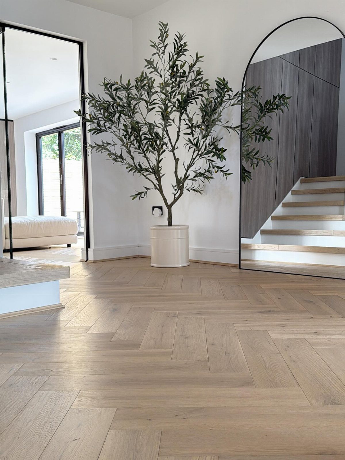 Light wood flooring featuring a herringbone pattern in a bright, modern interior room.